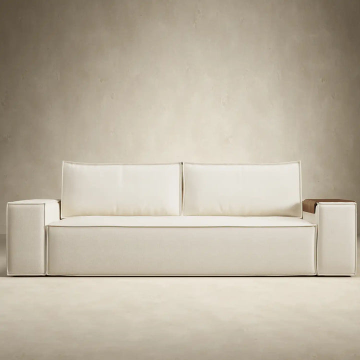 Play sofa bed with wide arms in soft cream fabric. Shown with one walnut arm tray